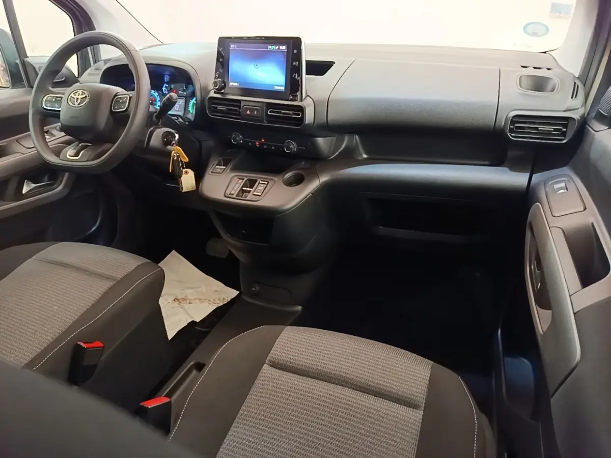 Vue intérieure avant du Toyota Proace City Verso électrique 2022, tableau de bord avec écran tactile et sièges gris.