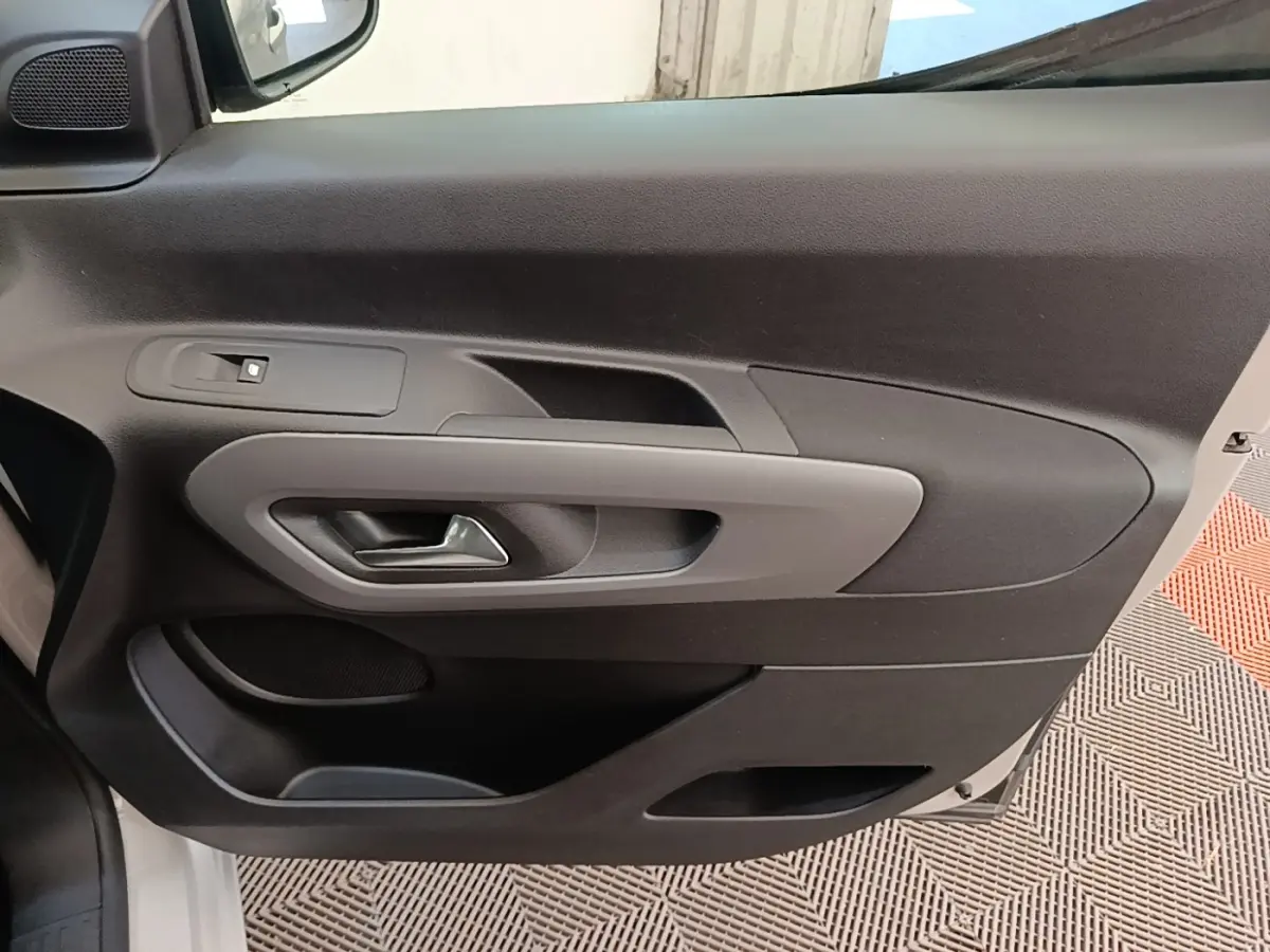 Détail de la porte intérieure côté conducteur du Toyota Proace City Verso électrique 2022, avec poignée grise et commande de fenêtre.