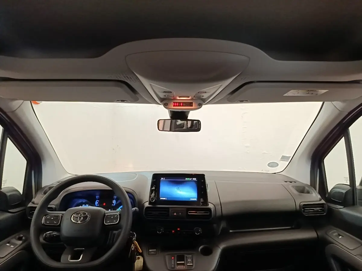 Vue intérieure frontale du tableau de bord gris foncé et volant multifonctions du Toyota Proace City Verso électrique 2022.
