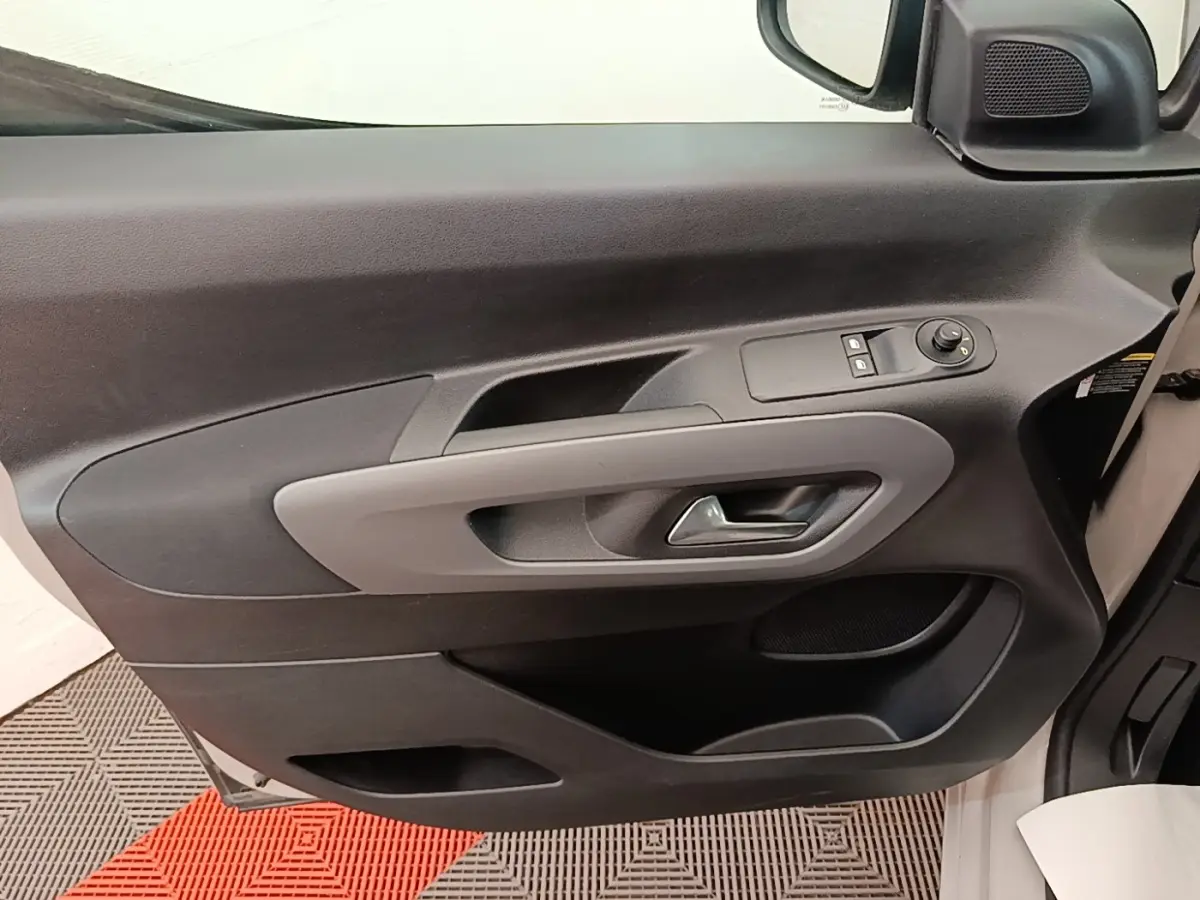 Vue intérieure de la porte avant gauche gris clair du Toyota Proace City Verso Electric avec commandes de vitres et rétroviseur.