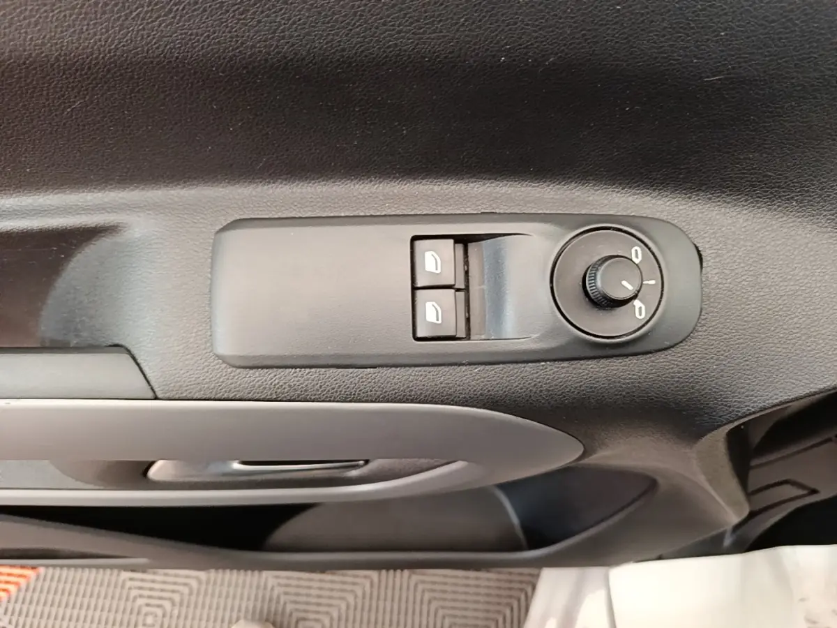 Gros plan sur les commandes de réglage des rétroviseurs et vitres sur la porte intérieure côté conducteur du Toyota Proace City Verso gris.