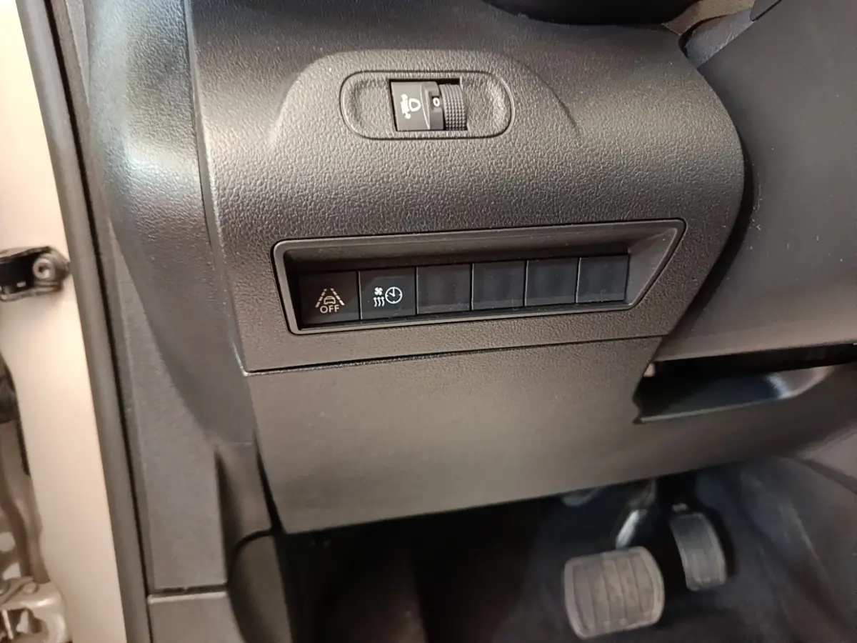 Détail intérieur côté gauche du tableau de bord gris foncé avec commandes d'assistance et pédales visibles du Toyota Proace City Verso électrique.