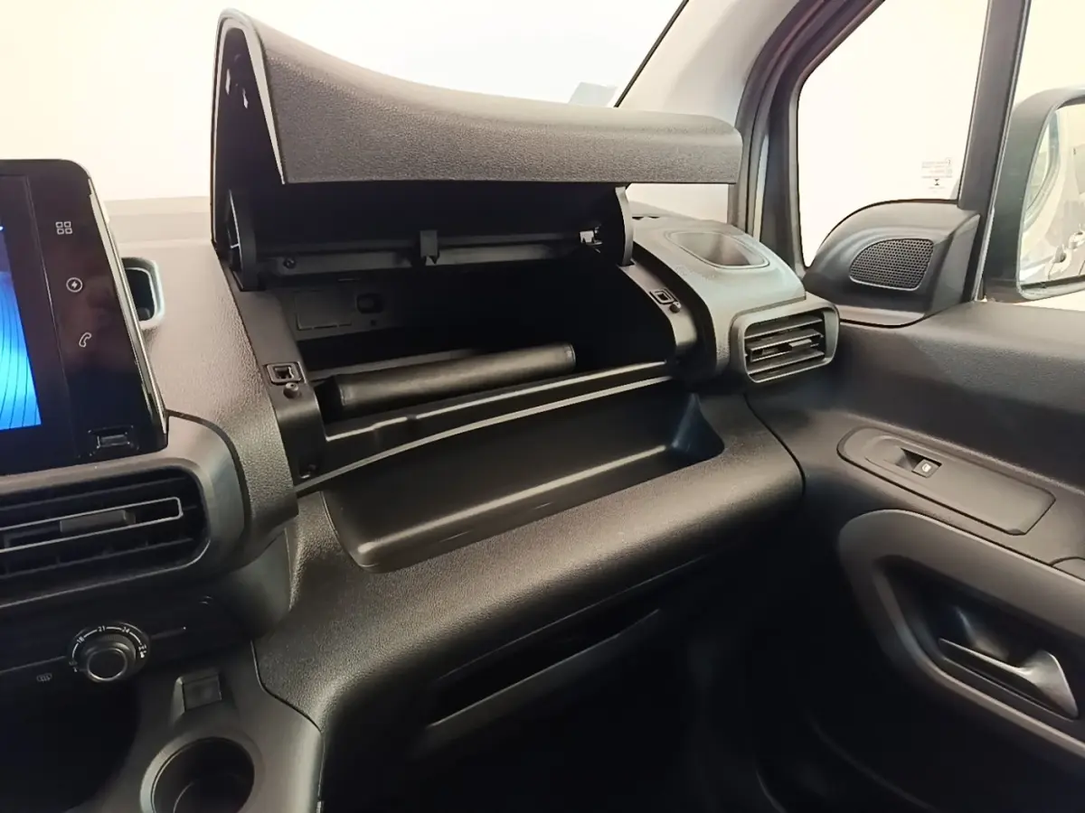 Vue intérieure côté passager du Toyota Proace City Verso électrique 2022, montrant la boîte à gants ouverte et la console noire.