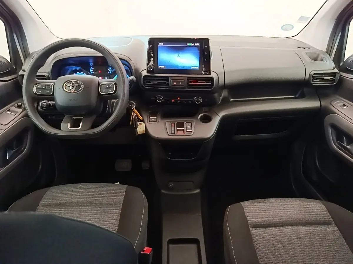 Vue intérieure avant du Toyota Proace City Verso électrique 2022, tableau de bord noir avec écran tactile central.