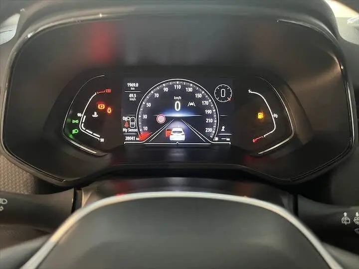 Tableau de bord numérique de Renault Clio V 1.0 TCE 90 Intens, affichant la vitesse et alertes, vue frontale rapprochée.