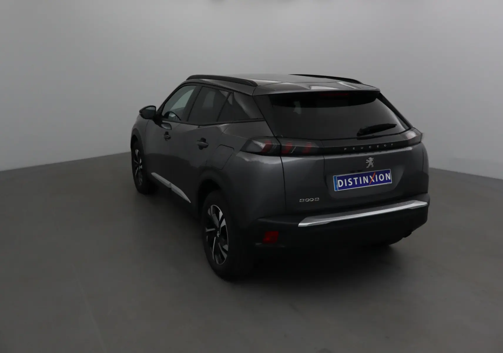 Vue 3/4 arrière droite d'un Peugeot 2008 gris platinium avec feux arrière LED et jantes alliage 17 pouces.