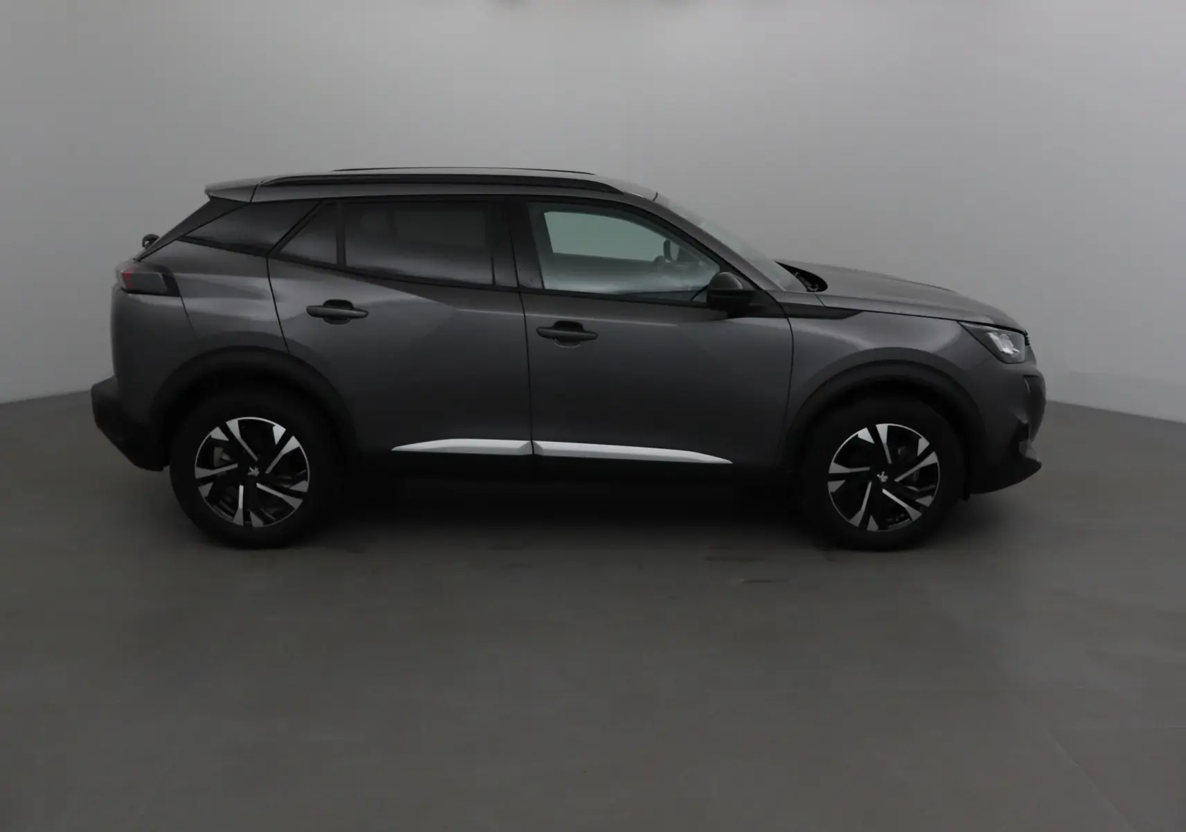 Peugeot 2008 gris platinium vue de profil côté droit, soulignant ses jantes noires et détails chromés.