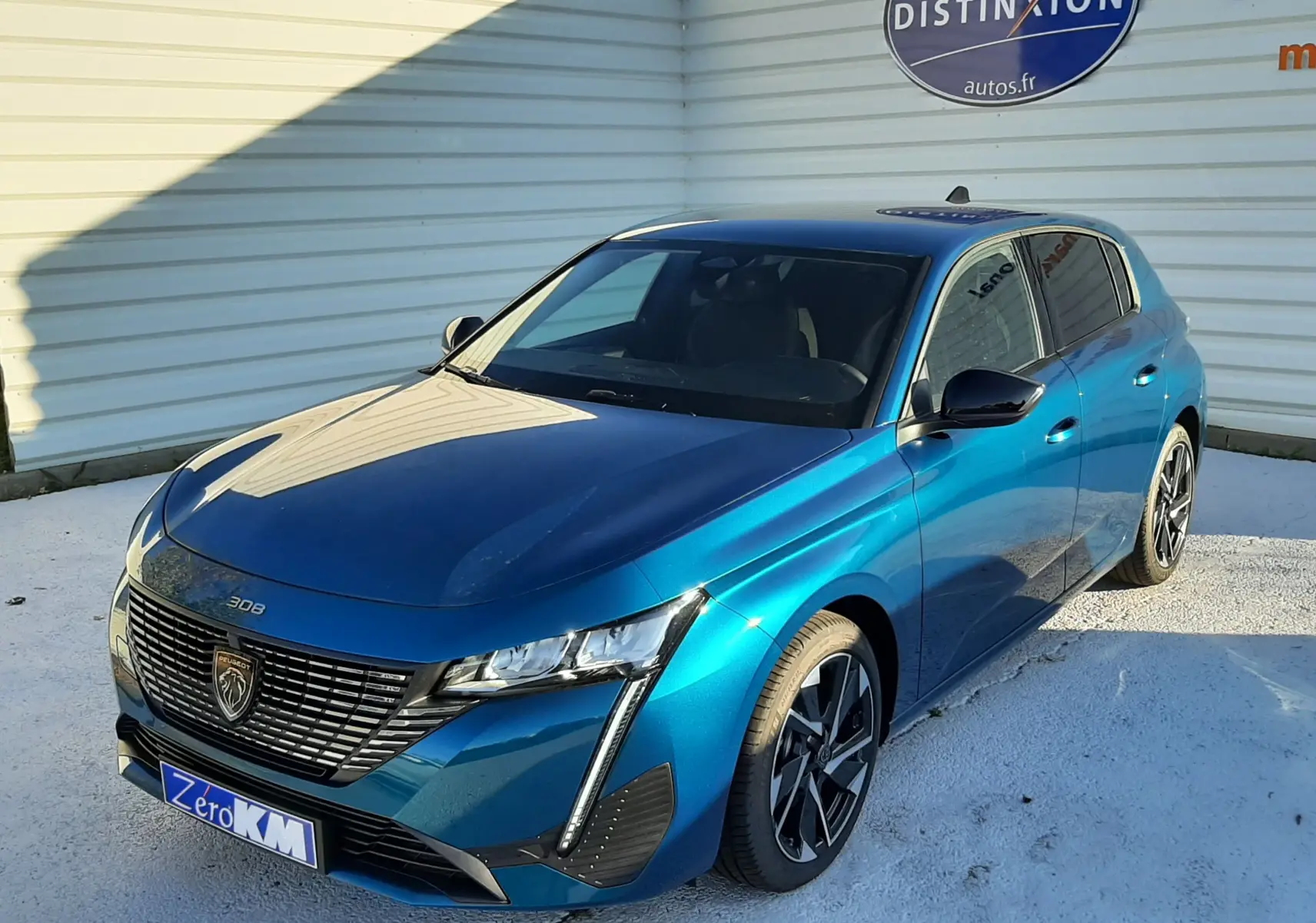 PEUGEOT 308 Bleu Obsession en 3/4 avant droit, avec calandre noire distinctive et jantes alliage bicolores.