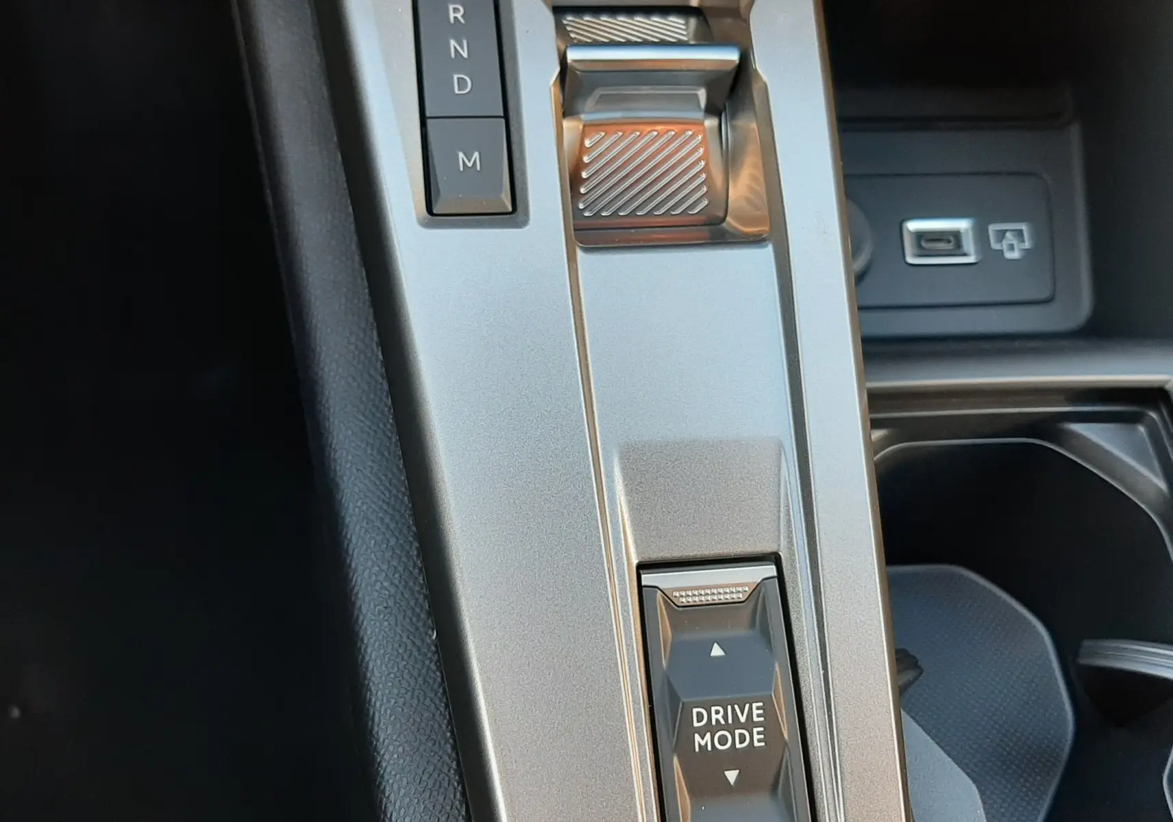 Gros plan sur la console centrale argentée de la Peugeot 308 Bleu Obsession, avec levier de vitesses et bouton Drive Mode.