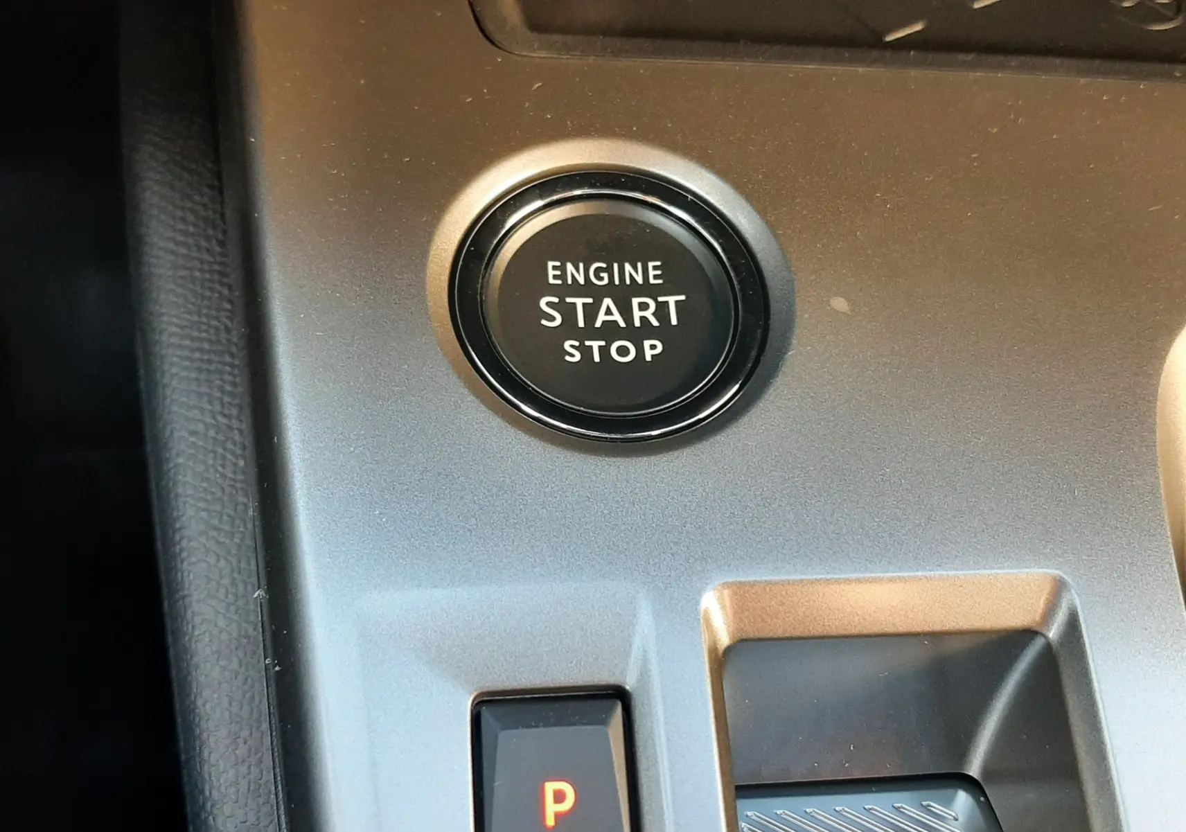 Bouton start/stop moteur et commande de boîte automatique sur console intérieure grise d'une Peugeot 308 Bleu Obsession.