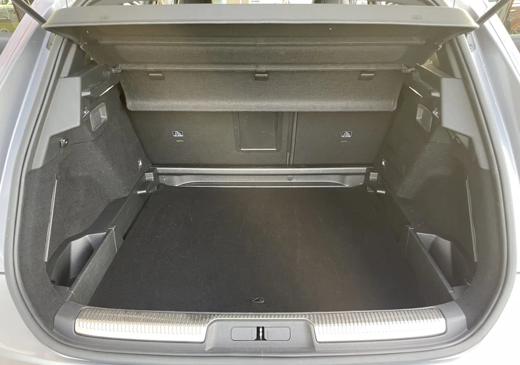 Coffre ouvert du DS7 gris, vue de l'arrière montrant un espace de chargement propre et bien agencé.