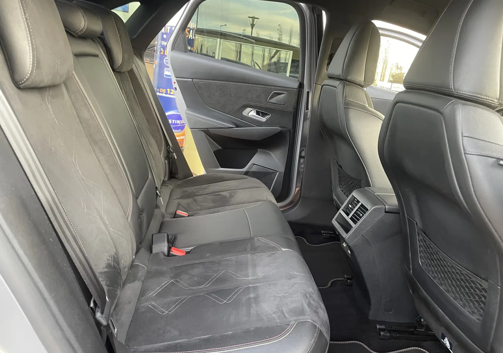 Vue intérieure arrière côté gauche du DS7 1.5 BLUEHDi gris, sièges en cuir et alcantara noir avec surpiqûres contrastées.