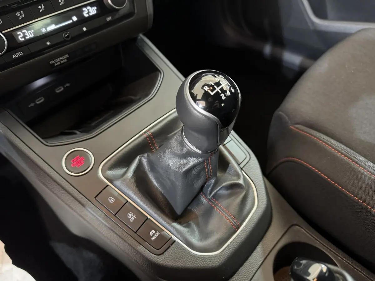 Le levier de vitesses manuel noir avec surpiqûres rouges de la SEAT IBIZA 1.0 TSI 110 FR vue en gros plan intérieur.