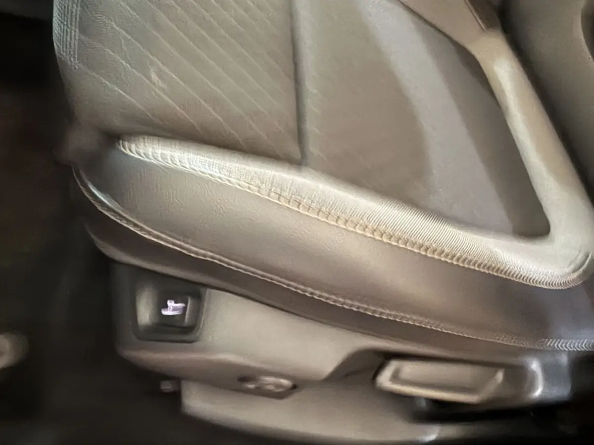 Détail du siège avant en cuir gris clair de l’Opel Grandland X, bouton de réglage électrique visible sous l’assise.