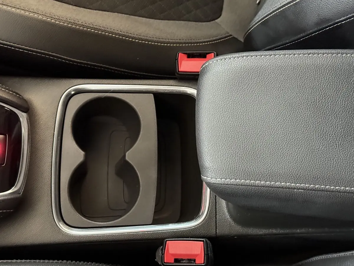 Gros plan sur la console centrale noire de l'Opel Grandland X 2021 avec porte-gobelets et accoudoir cuir.