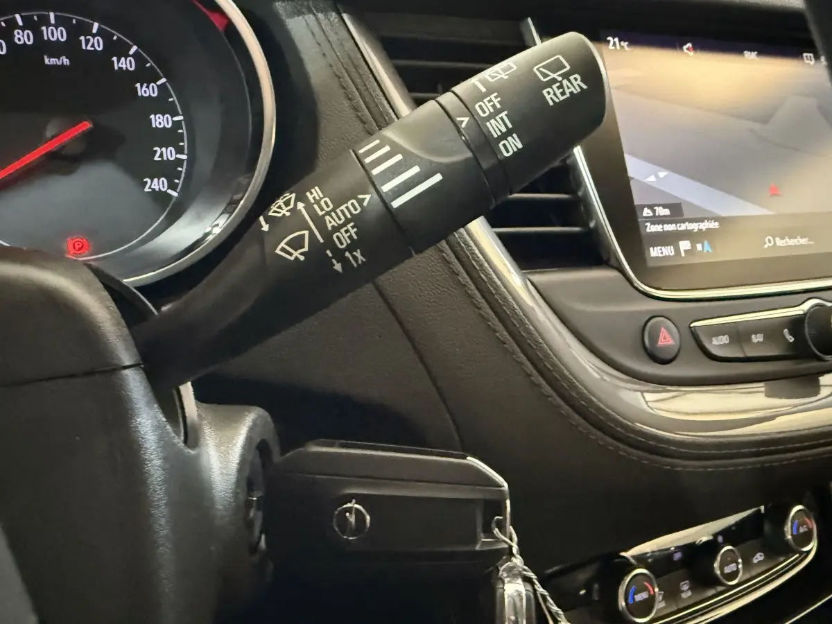 Détail intérieur du tableau de bord de l’Opel Grandland X 2021, avec commandes essuie-glaces et écran tactile de navigation.