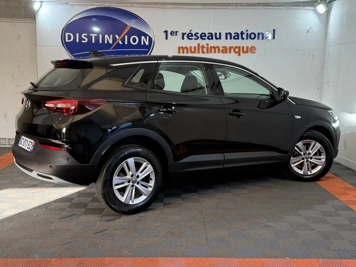 Opel Grandland X noir vue de profil côté droit, stationné en intérieur avec jantes alliage visibles.