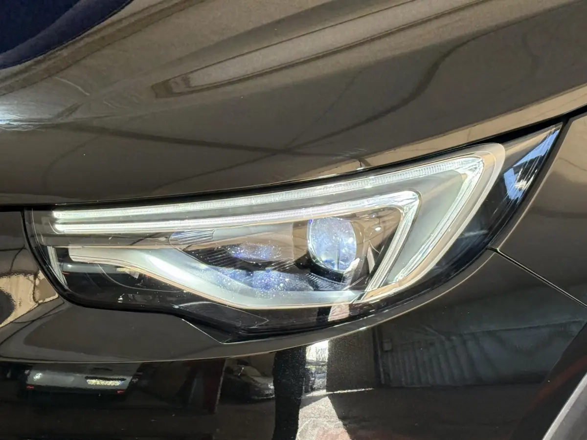Gros plan sur le phare avant droit du SUV Opel Grandland X noir, mettant en valeur son design LED moderne.