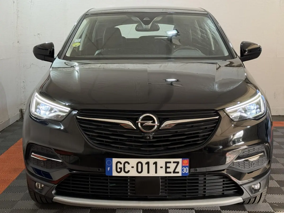 Vue frontale d'un Opel Grandland X noir avec phares LED allumés et calandre noire distinctive.