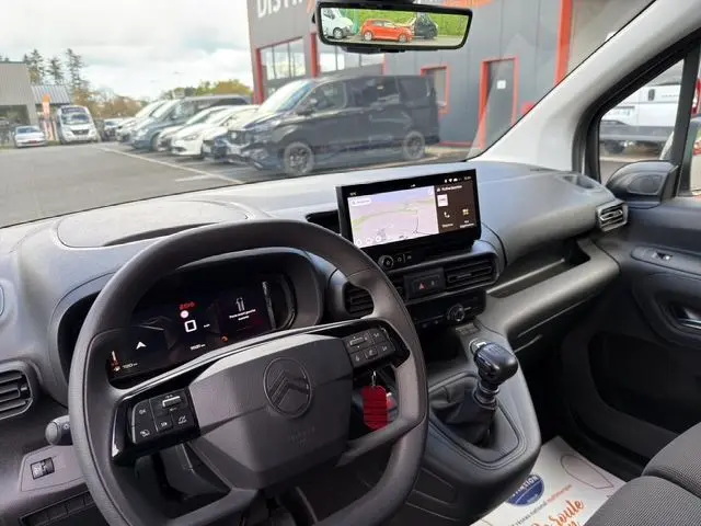 Vue intérieure côté conducteur du Citroën Berlingo blanc 2025, avec tableau de bord numérique et écran tactile central.