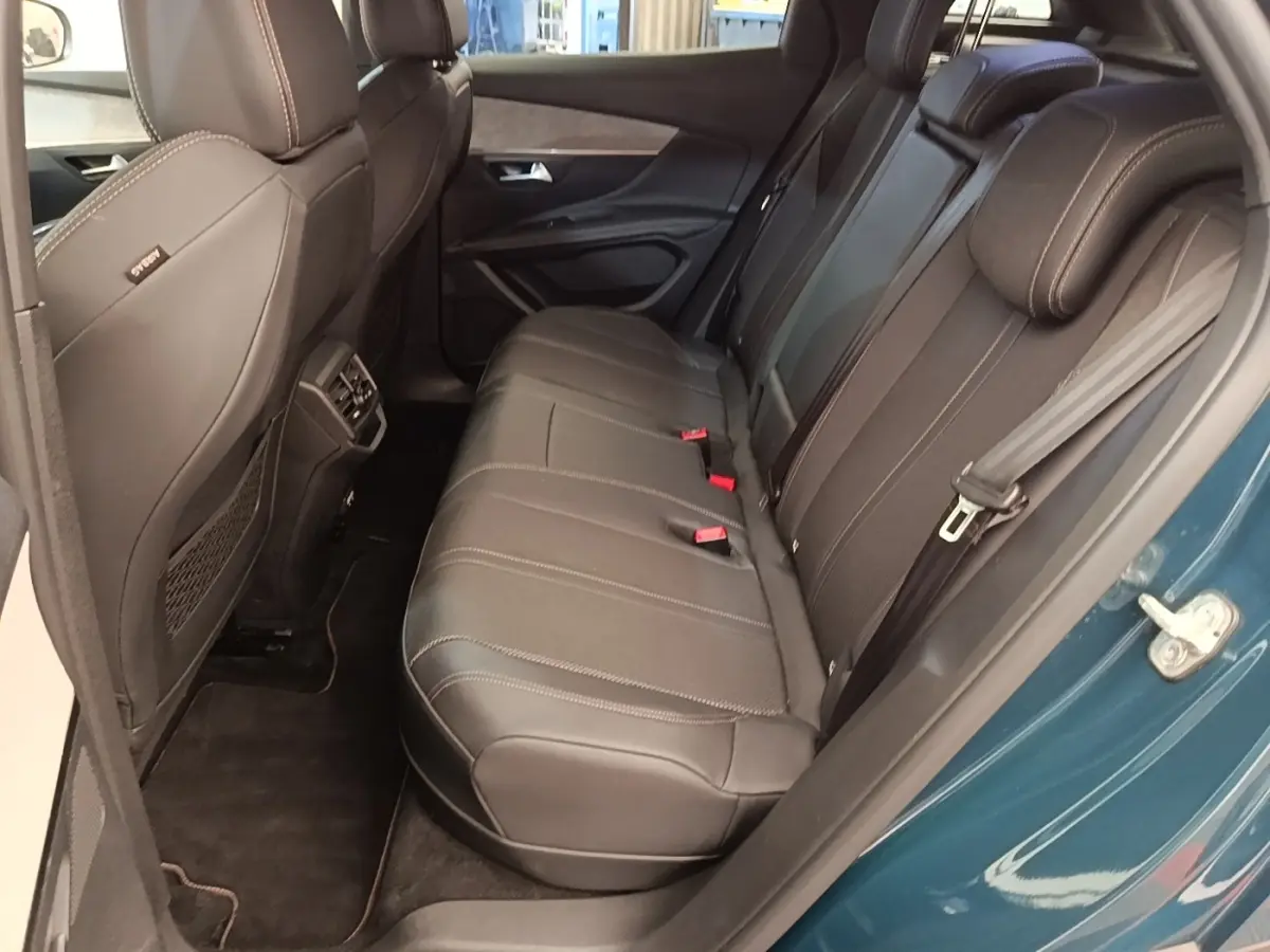 Vue côté droit de la banquette arrière en cuir noir du Peugeot 3008 bleu hybride rechargeable, porte ouverte.