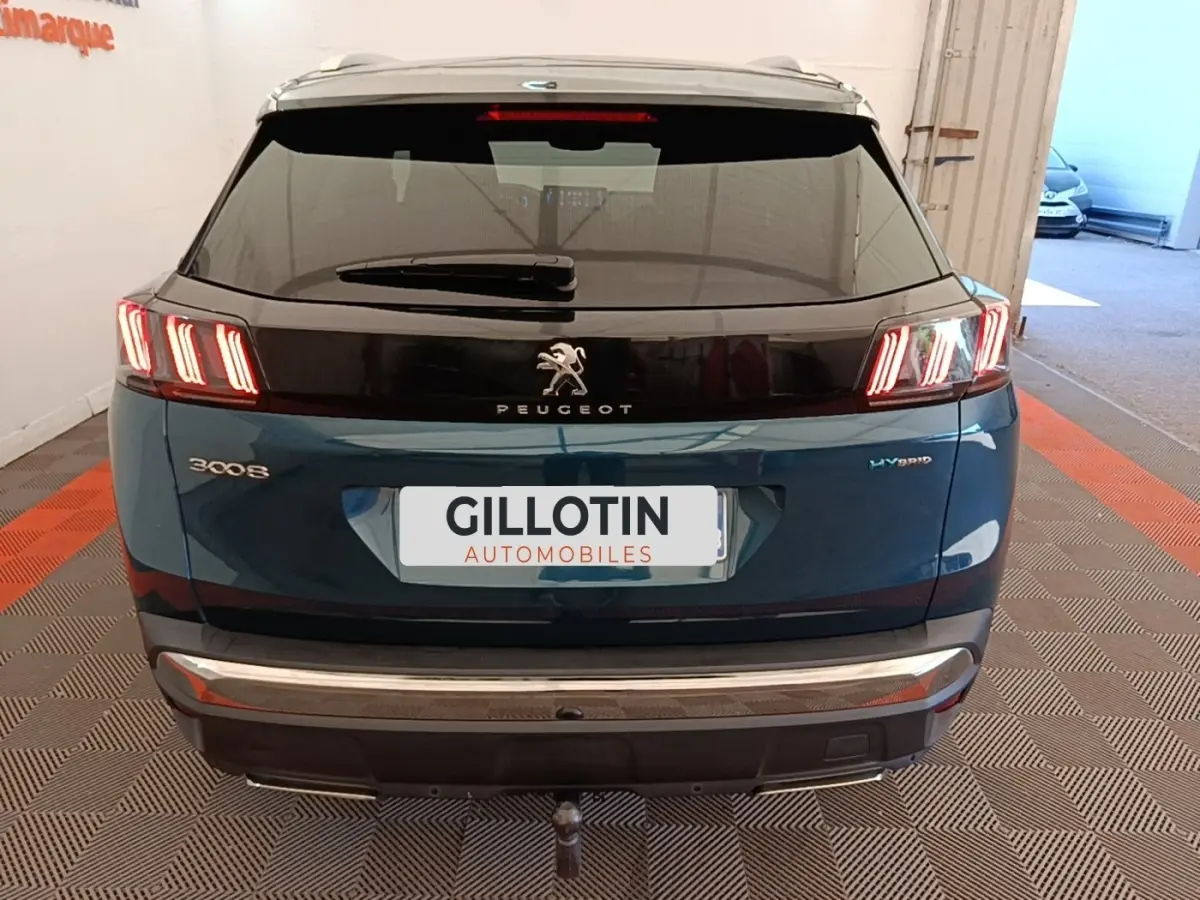 Vue arrière d’un Peugeot 3008 hybride bleu 2022 avec feux LED distinctifs et logo central sur hayon noir.