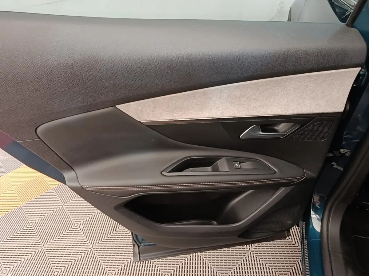 Vue intérieure de la porte arrière droite du Peugeot 3008 bleu, avec garniture noire et insert tissu clair.