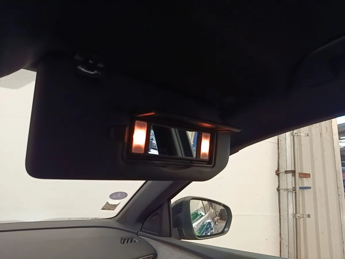 Vue intérieure côté gauche du Peugeot 3008 bleu, avec miroir de courtoisie éclairé sur pare-soleil.