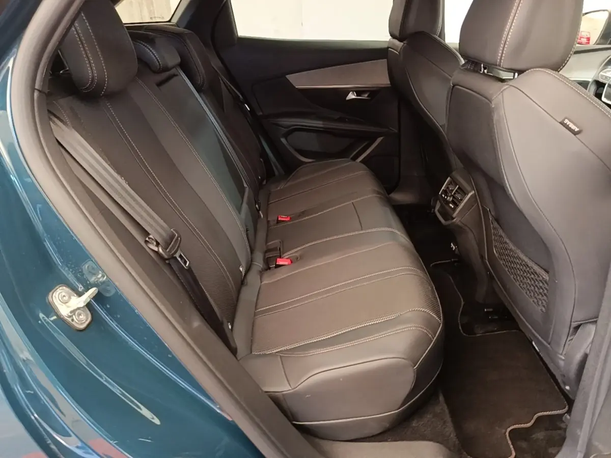 Vue intérieure côté gauche sur la banquette arrière en cuir noir du Peugeot 3008 bleu hybride rechargeable 2022.