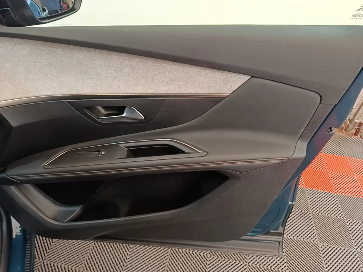 Vue intérieure de la porte avant gauche du Peugeot 3008 bleu, avec panneau en tissu clair et garniture noire.