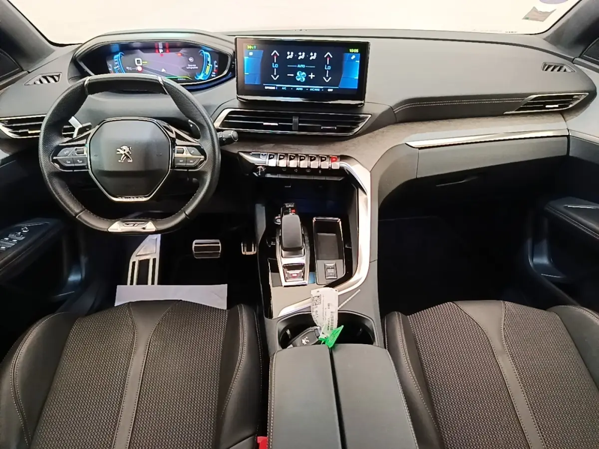 Intérieur du Peugeot 3008 GT 1.6 Hybrid 225, vue frontale du tableau de bord avec écran tactile et volant cuir multifonctions.