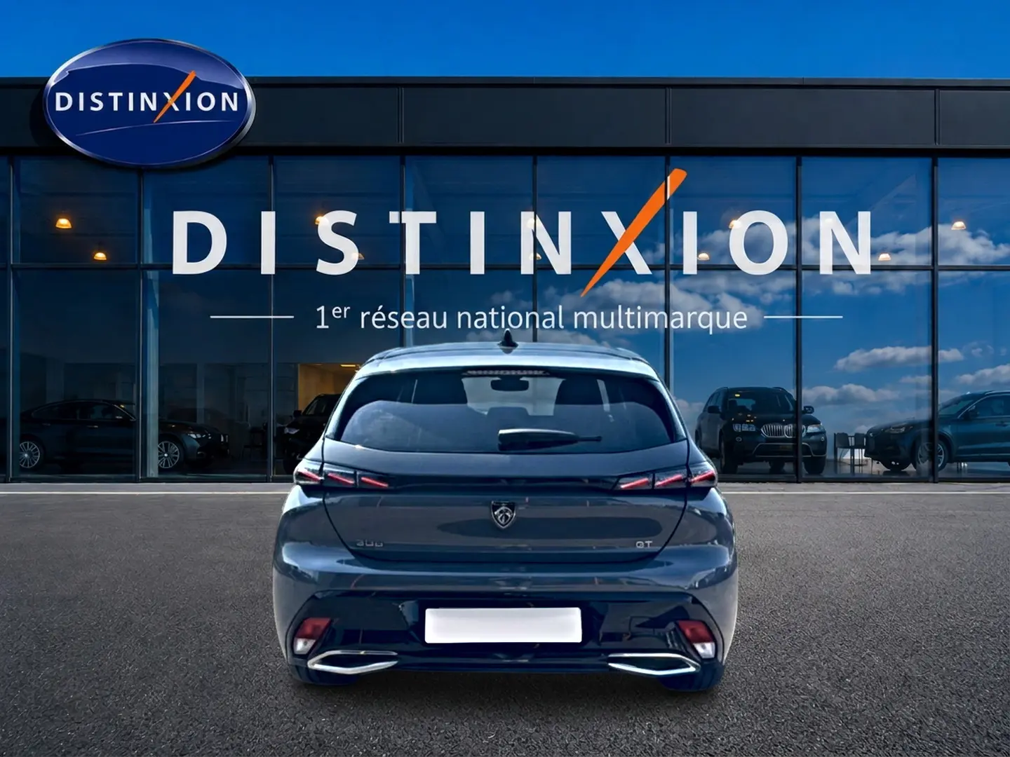 Vue arrière d'une Peugeot 308 gris métallisé 2025 GT avec feux LED et double sortie d'échappement chromée.