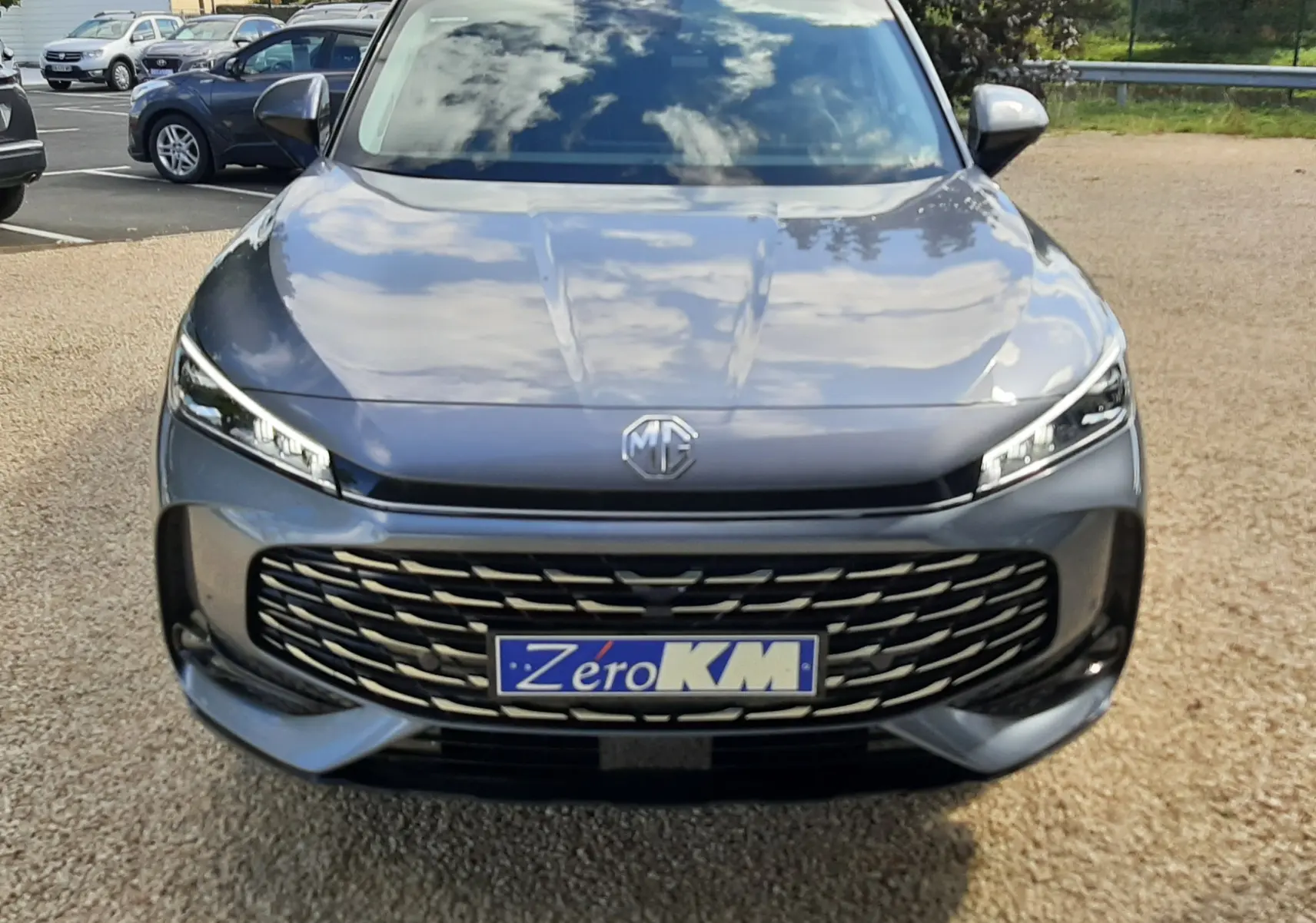 Vue avant d'un MG Motor EHS 1.5 Hybrid+ 224ch Luxury en Camden Grey avec calandre large et phares LED fins.