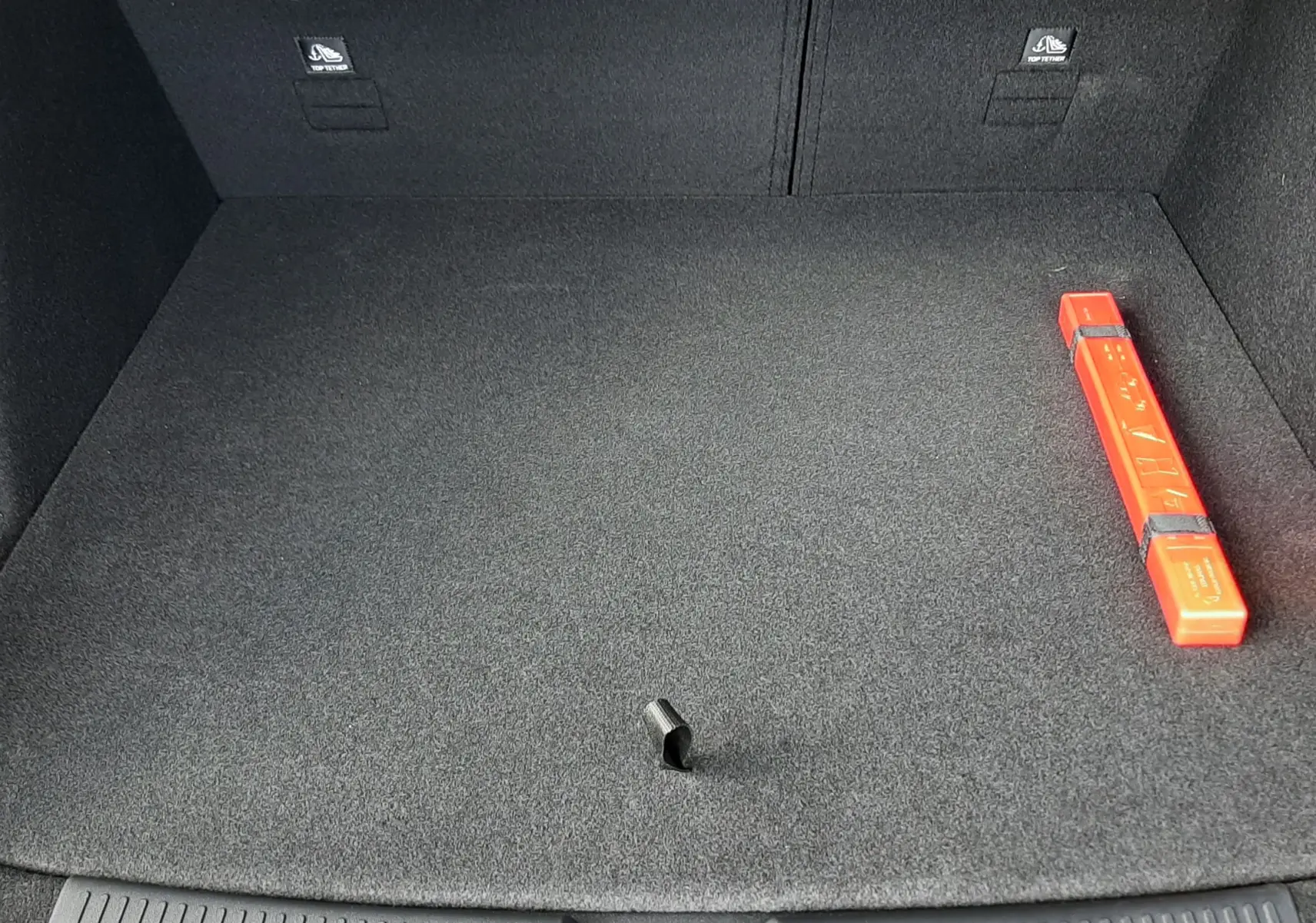 Vue plongeante sur le coffre spacieux et propre du MG MOTOR EHS Camden Grey 2026, avec triangle de signalisation rouge visible.