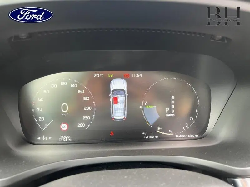 Tableau de bord numérique du Volvo V60 T8 gris Savile, affichant vitesse, autonomie et mode hybride en vue frontale.