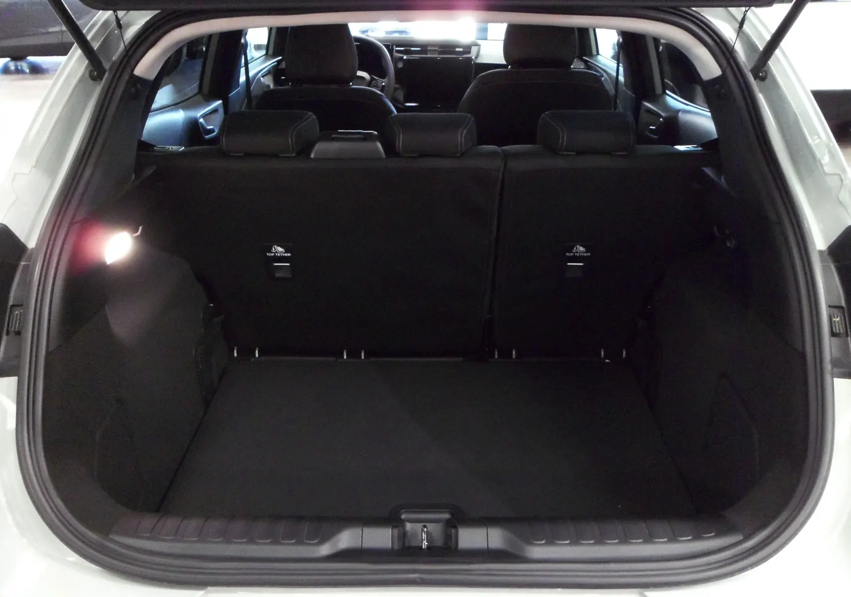 Coffre ouvert vu de l'arrière d'un Ford Puma gris Cactus 2025, montrant l'espace de chargement et les sièges arrière.