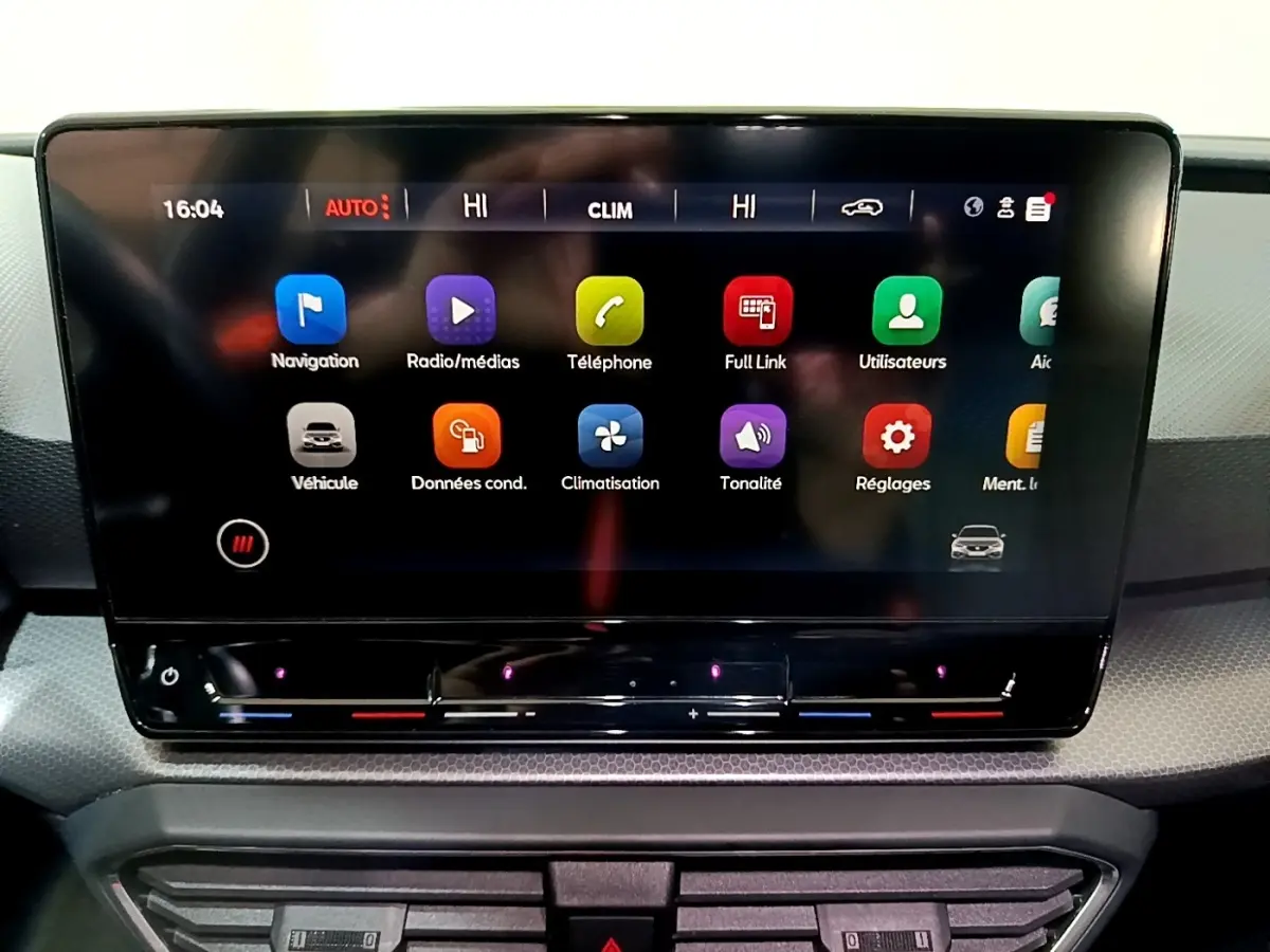 Écran tactile central de la SEAT Leon 2023 affichant les icônes de navigation et climatisation en gros plan.