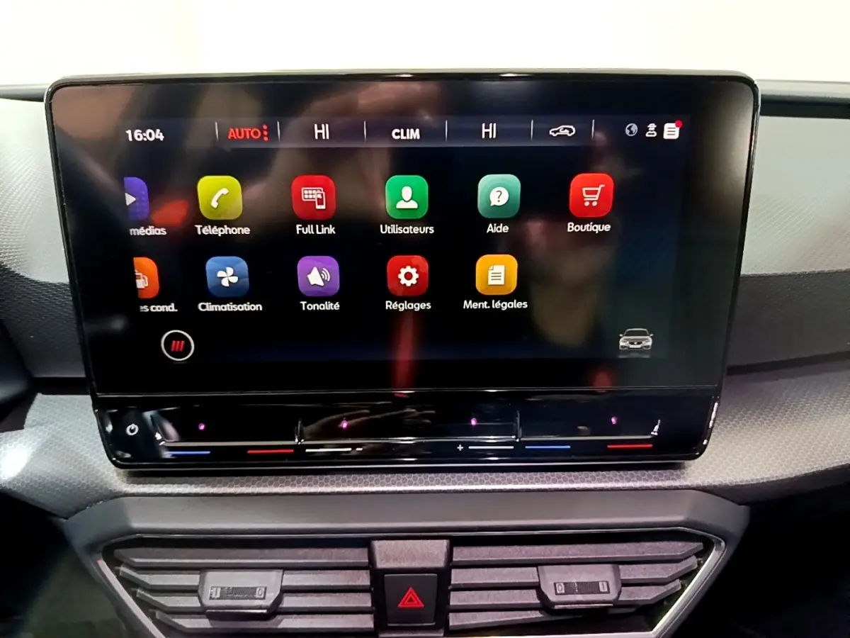 Écran tactile central du tableau de bord de la SEAT Leon 2023, affichant les menus multimédias et climatisation.