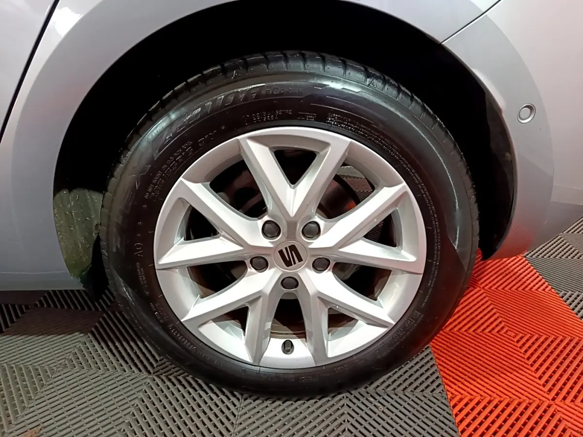 Gros plan sur la roue avant droite gris clair de la SEAT LEON 2023 avec jante alliage à 5 doubles branches