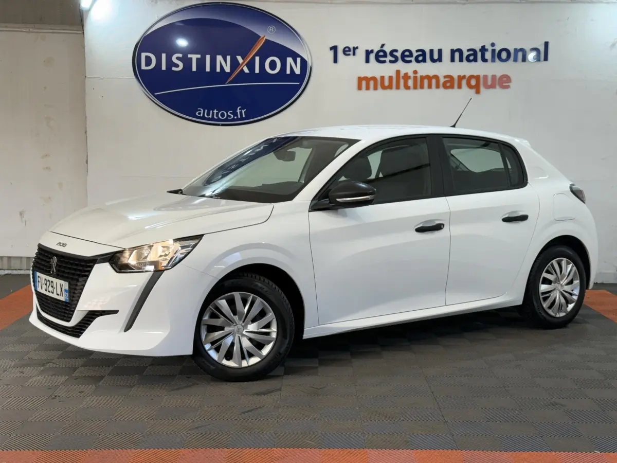 Peugeot 208 blanche vue de côté droit 3/4 avant, avec calandre noire et jantes argentées en intérieur showroom.