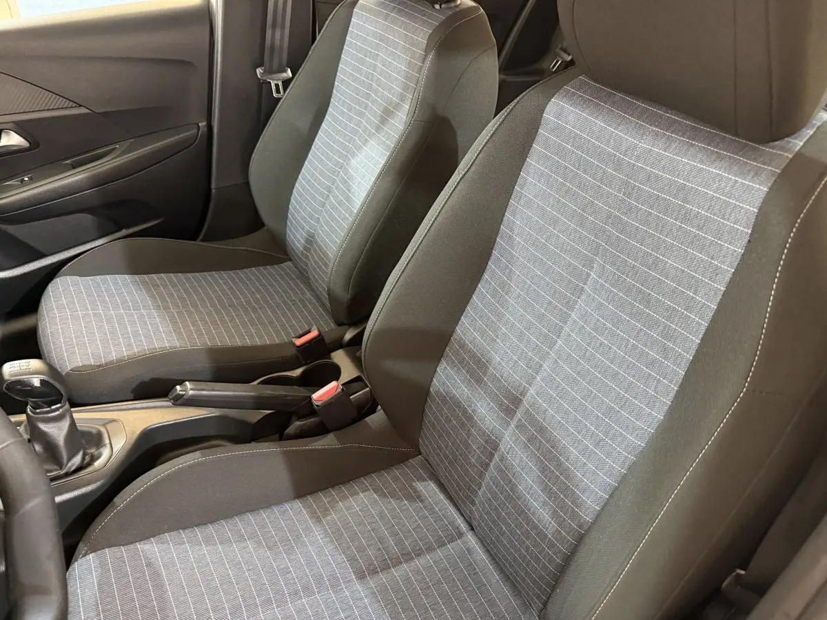 Vue intérieure rapprochée des sièges avant gris à motifs rayés de la Peugeot 208 PureTech 75 S&S Like 2020.