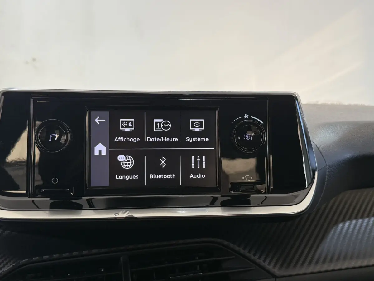 Écran tactile central de la Peugeot 208 PureTech 75 S&S Like 2020 avec menu affichage et Bluetooth, tableau de bord noir.