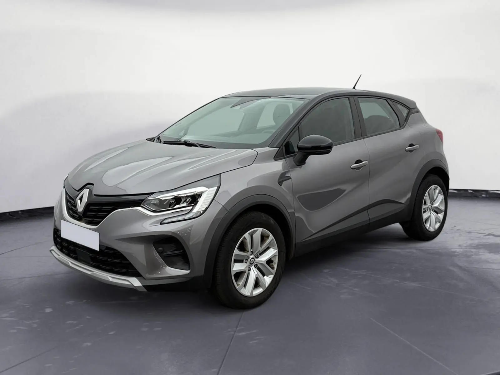Renault Captur TCE 140 2022 gris Cassiopée avec toit noir, vue 3/4 avant droit, jantes alliage et calandre marquée.