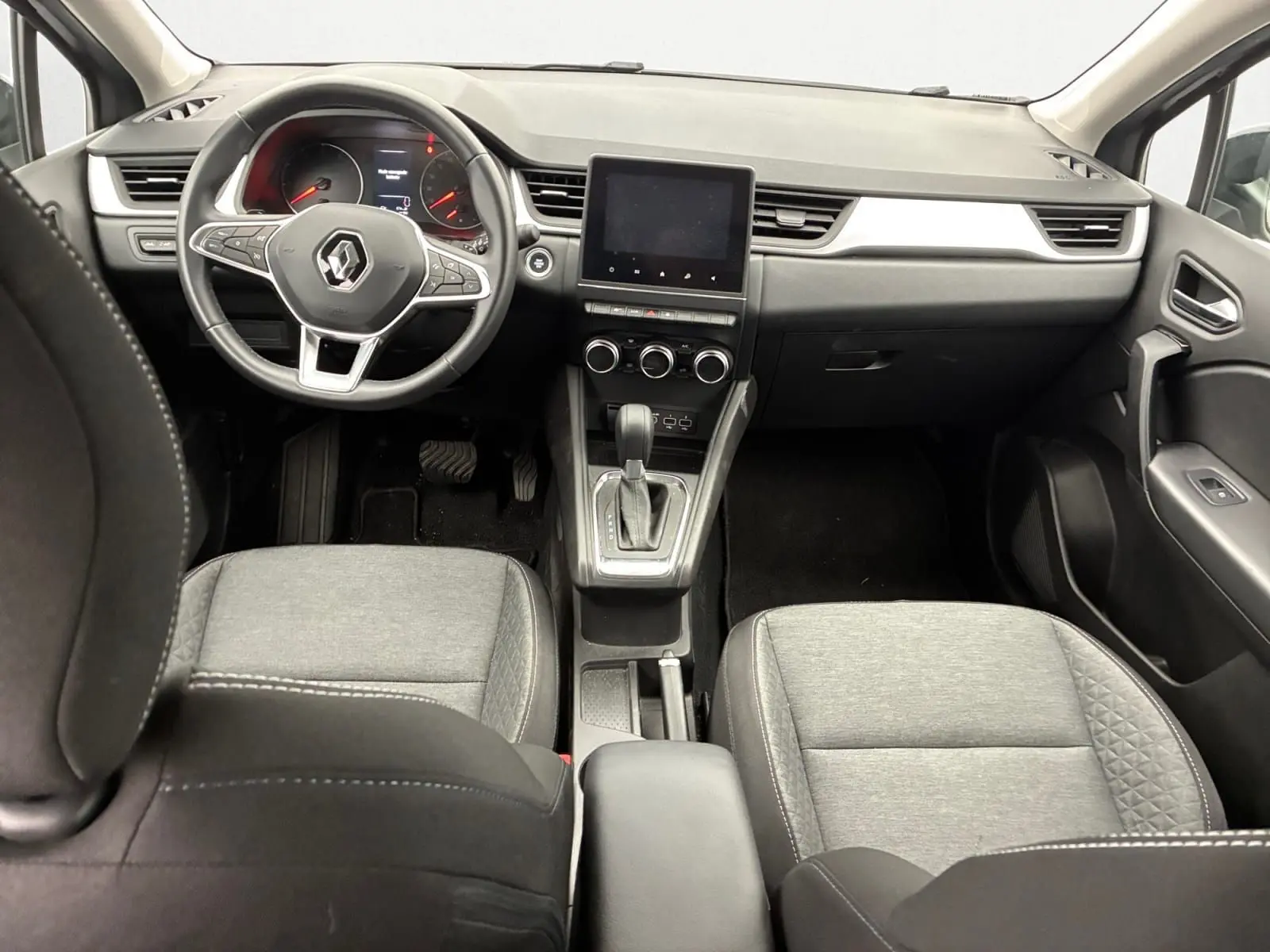 Vue intérieure avant du Renault Captur TCE 140 Business 2022, sellerie tissu gris et tableau de bord noir.
