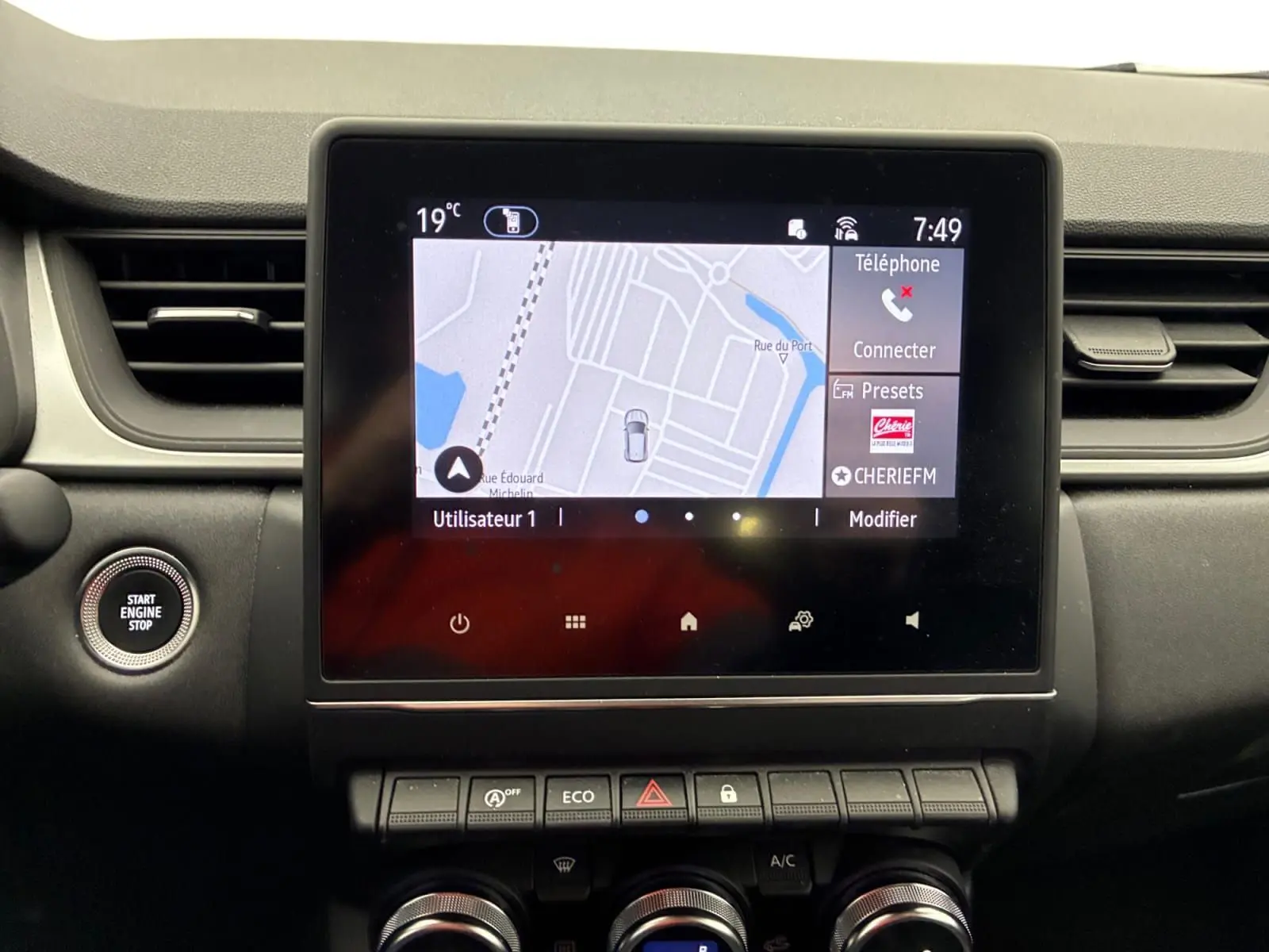 Écran tactile central avec navigation affichée, boutons de commande en dessous, intérieur noir du Renault Captur 2022.