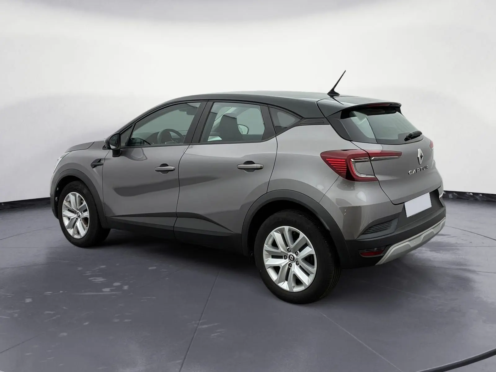 Vue 3/4 arrière droit du Renault Captur gris Cassiopée avec toit noir et roues 17 pouces, en studio.