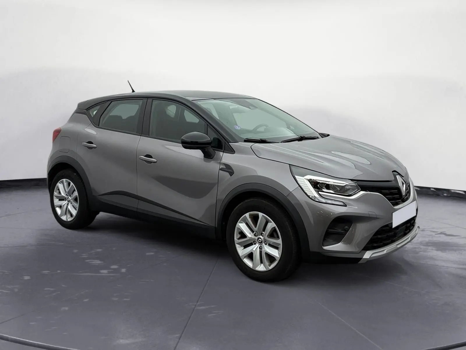 Renault Captur TCE 140 Business gris Cassiopée avec toit noir, vue 3/4 avant droit, roues 17 pouces et caméra de recul.