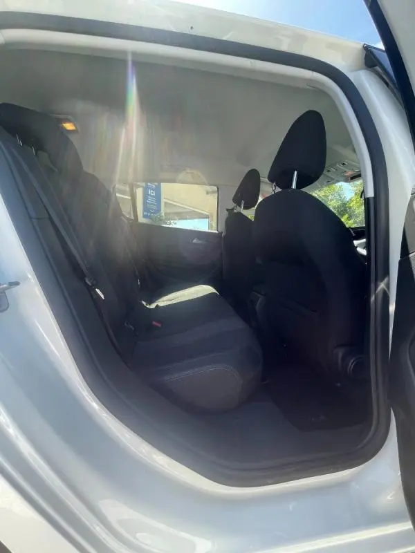 Vue intérieure côté gauche sur les sièges arrière noirs d'une Peugeot 308 blanche, version 5 portes, année 2020.