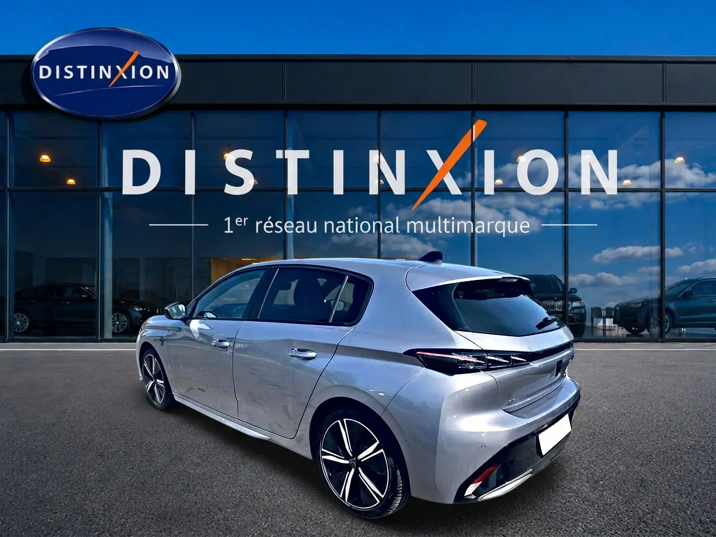 Peugeot 308 gris en 3/4 arrière droit, mettant en valeur ses jantes alu et feux arrière LED distinctifs.