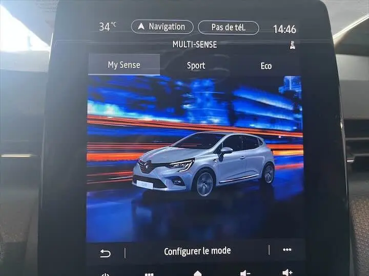 Affichage intérieur de l'écran multimédia montrant une Renault Clio V blanc nacré en vue 3/4 avant droite avec options de conduite Multi-Sense.